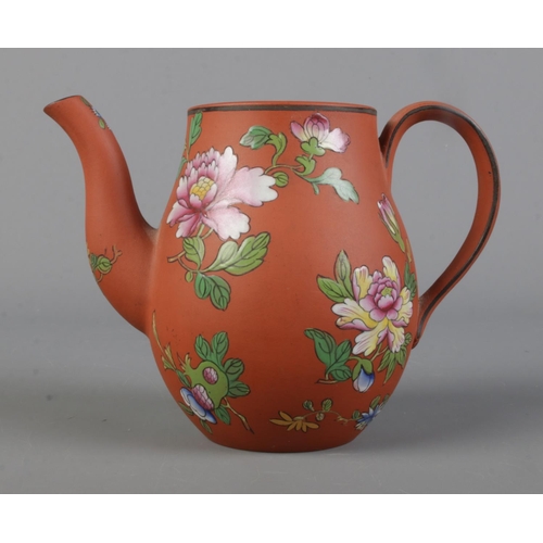 456 - A Wedgwood Rosso Antico teapot featuring enameled floral decoration.