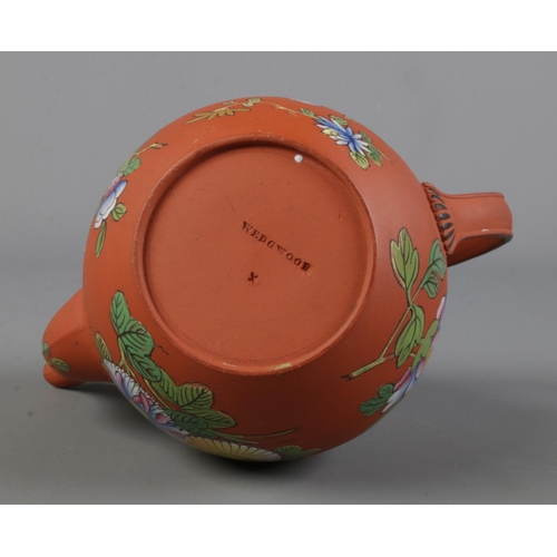 456 - A Wedgwood Rosso Antico teapot featuring enameled floral decoration.