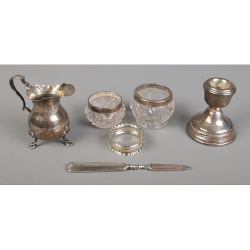 464 - A small quantity of silver. Includes weight dwarf candlestick, napkin ring, silver cream jug, etc.