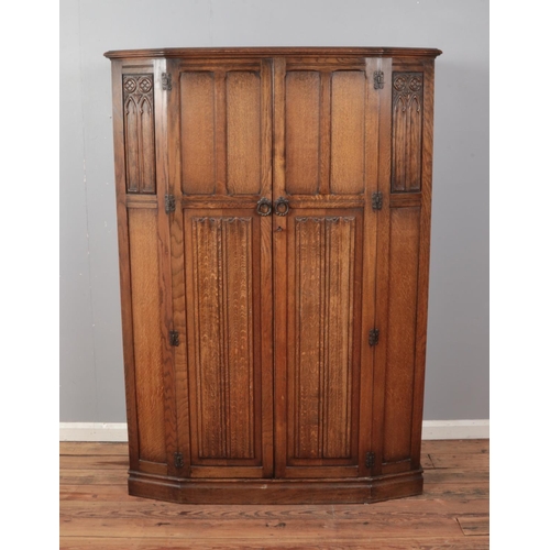 515 - A mid 20th century oak wardrobe with linen fold carved panels made by 