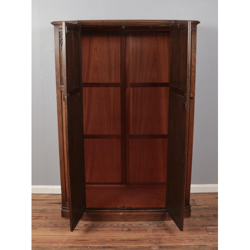 515 - A mid 20th century oak wardrobe with linen fold carved panels made by 