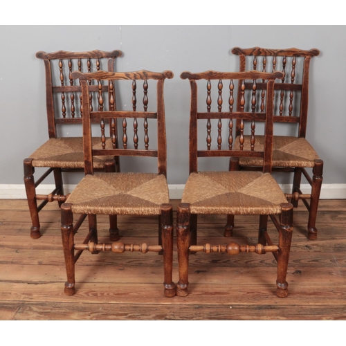 517 - A set of four spindle back chairs with rush seats.