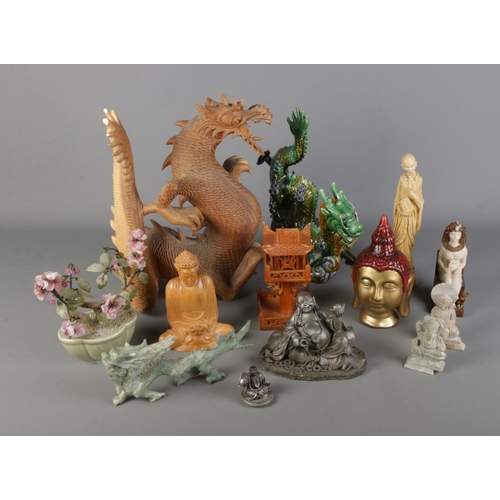 335 - A quantity of oriental figures including large wooden dragon, various buddha examples and soapstone ... 