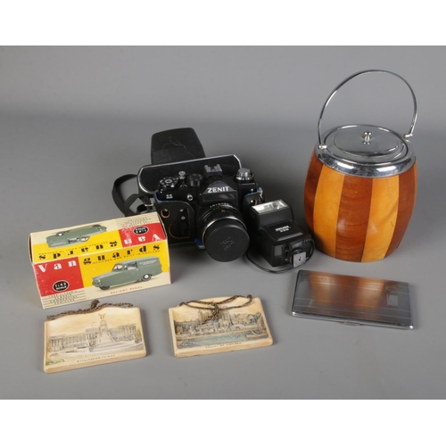 321 - A mixed quantity of collectables including a biscuit barrel, Richmond cigarette case, Zenit 11 camer... 