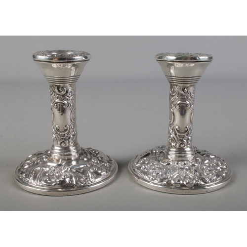 480 - A pair of silver filled candlesticks each with repousse bird and foliate decoration, Birmingham 1968... 