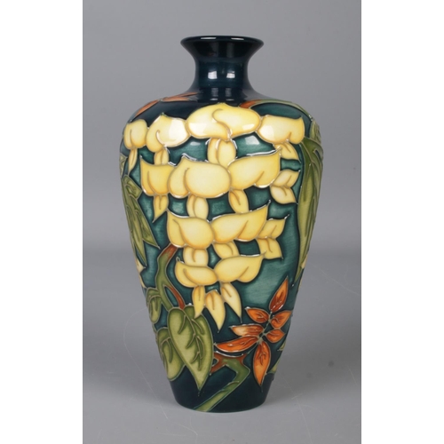 487 - A Moorcroft pottery blue ground vase in the 'Wisteria' pattern. Stamped to base, numbered 232 and wi... 