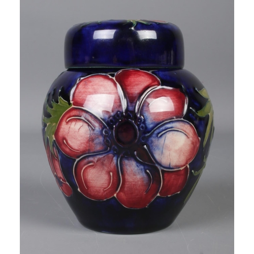 488 - A small Moorcroft pottery dark blue ground ginger jar with cover in the 'Anemone' design. With impre... 