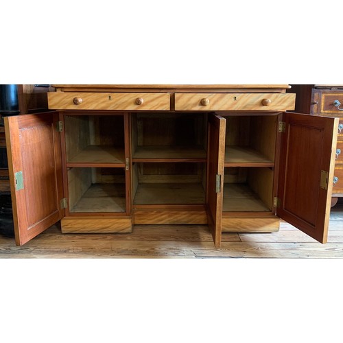 415 - A Victorian satin birch desk. Having two drawers over three cupboard doors. Height 81cm, Width 114cm... 