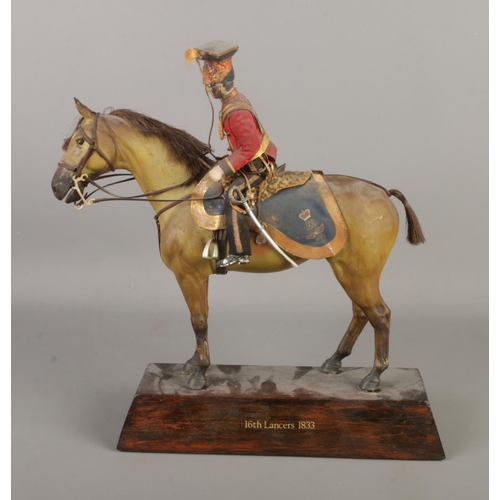 13 - An antique composite figure formed as a military soldier on horseback, base stamped 16th Lancers 183... 