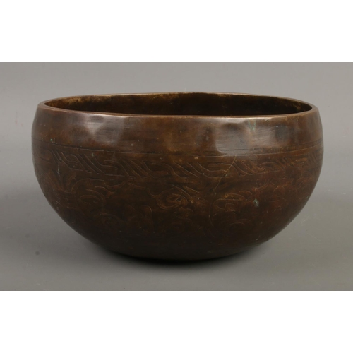 26 - A Tibetan singing bowl featuring Sanskrit decoration. Approx. diameter 15cm.