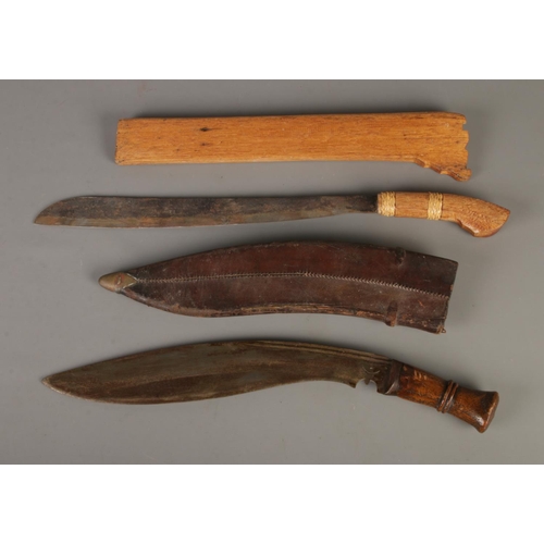 64 - Two knifes to include Kukri with leather sheath along with machete in wooden sheath. CANNOT POST OVE... 