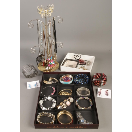 72 - A quantity of costume jewellery. Includes bracelets, necklaces and stand, earrings, etc