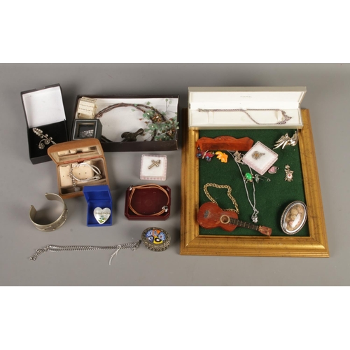 92 - A collection of mostly costume jewellery to include white metal bangle, pendants, and brooches. Incl... 