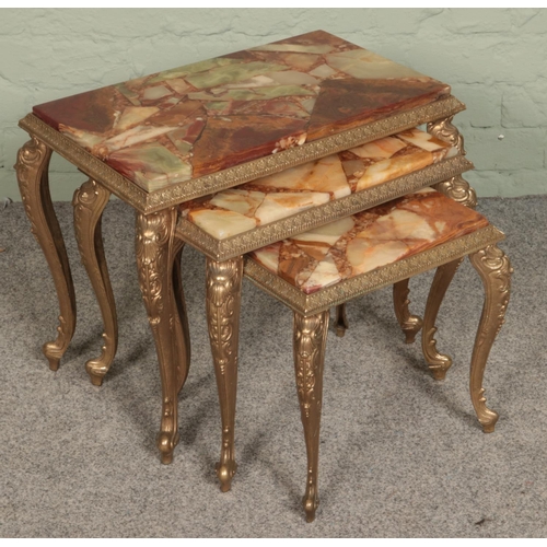 405 - A nest of three agate effect and gilt metal tables.