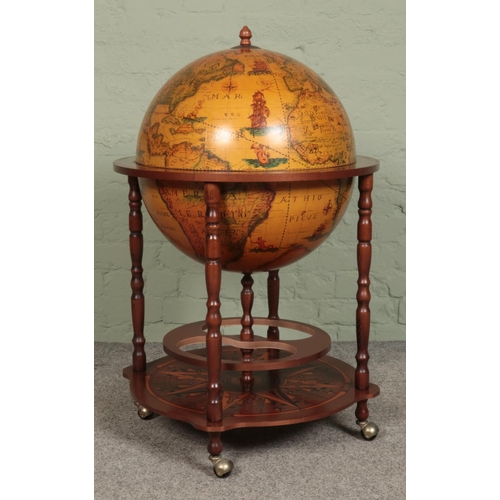 406 - A Globe drinks cabinet, with turned oak supports, hinged top, horoscopic border and rotating base. R... 