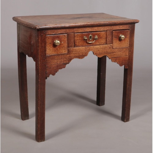 432 - A Georgian oak side table, having three drawers and raised on square cut legs. Height 75cm, Width 76... 