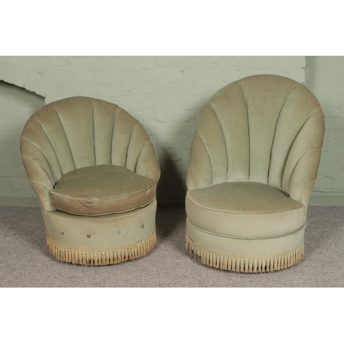 452 - Two bedroom chairs, in sage velvet upholstery with shell back and fringed base. Both raised on casto... 