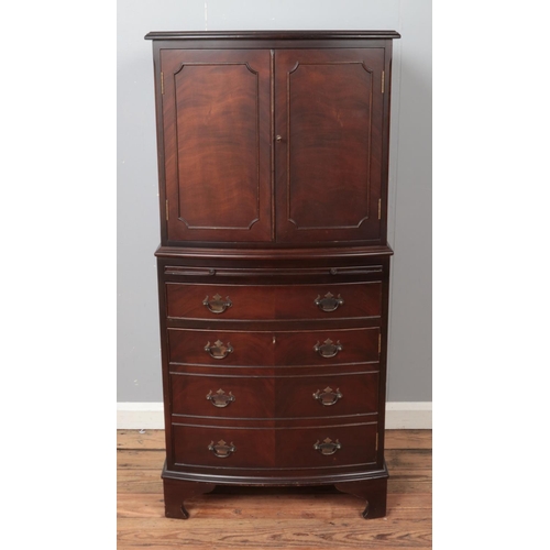 440 - A bow fronted mahogany drinks cabinet, with cupboard doors, pull-out shelf and fake drawers to the b... 