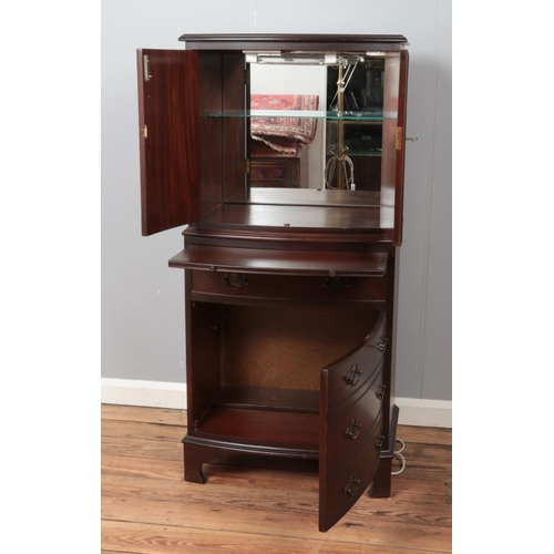 440 - A bow fronted mahogany drinks cabinet, with cupboard doors, pull-out shelf and fake drawers to the b... 