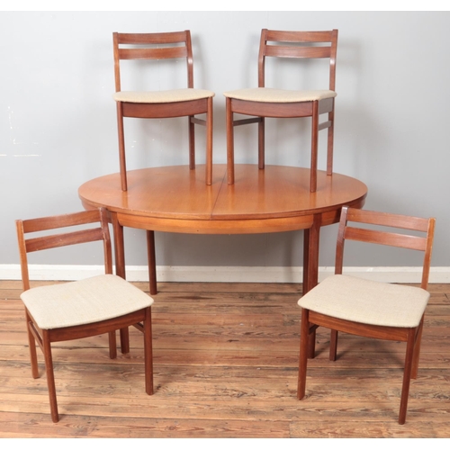 448 - A teak extending dining table along with set of four upholstered chairs.