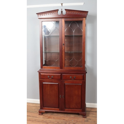 449 - A hardwood glazed display cabinet raised on drawer and cupboard base with lockable doors. Keys are p... 