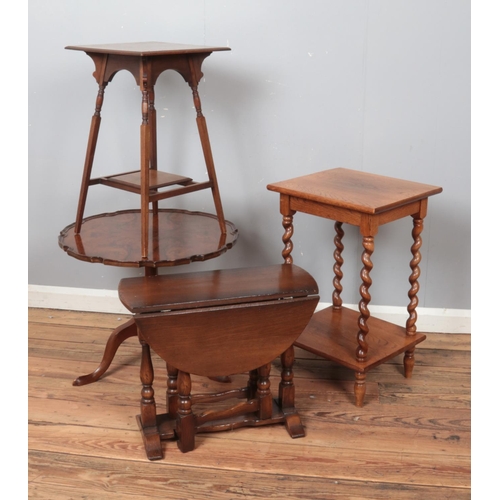 458 - Four occasional tables. Includes tilt top walnut example, two oak examples and a small drop leaf tab... 