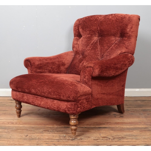 460 - A Howard style deep button back armchair, with scrolled arms, red upholstery and turned front suppor... 