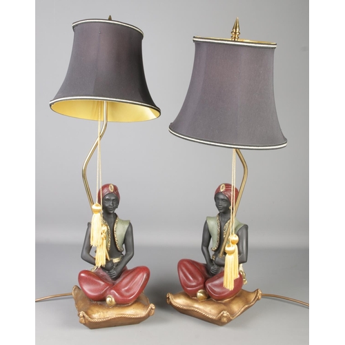 118 - A pair of decorative composite Blackamoor figural table lamps. Height of figures 32cm.