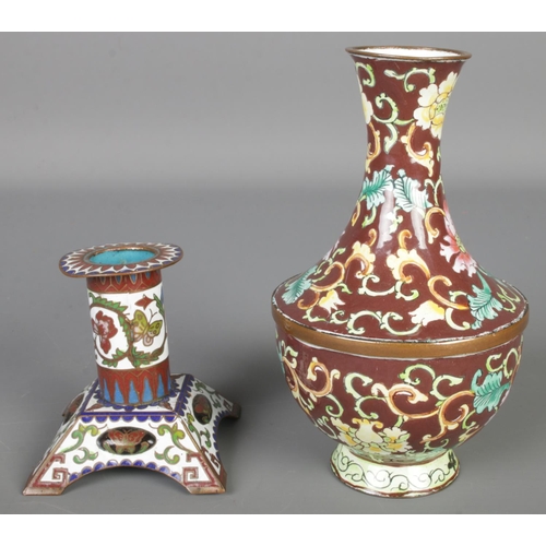 122 - A cloisonné vase and candlestick decorated with flowers. Vase 14cm.