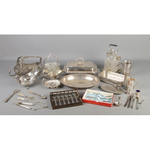 151 - A collection of silver plated items, to include four piece cruet set, wine bottle holder, lidded tur... 