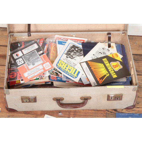 153 - A vintage leather suitcase with contents of assorted sporting programmes to include football, motorb... 