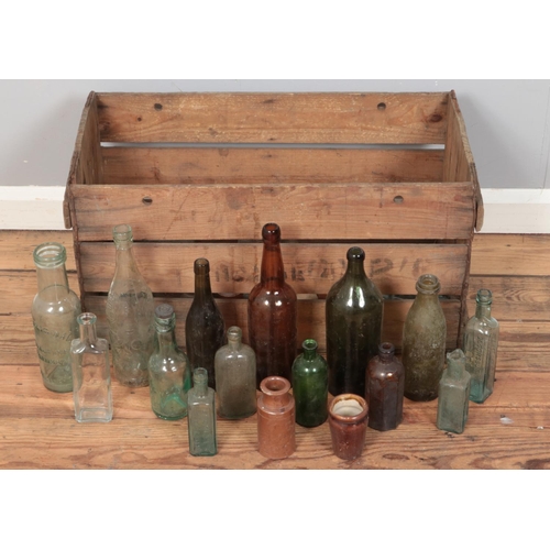 161 - A wooden crate with contents of mostly vintage glass advertising bottles. Includes