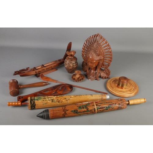 192 - A box of treen. Includes two oriental parasols, Banksia Seed vase, carved mask etc.