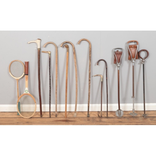 221 - A collection of walking sticks and shooting equipment, to include horn handled examples, along with ... 