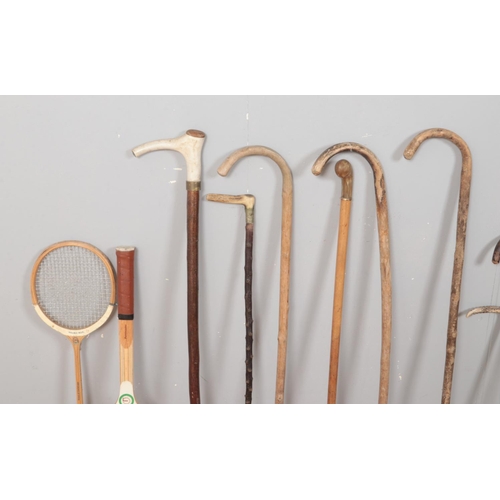 221 - A collection of walking sticks and shooting equipment, to include horn handled examples, along with ... 