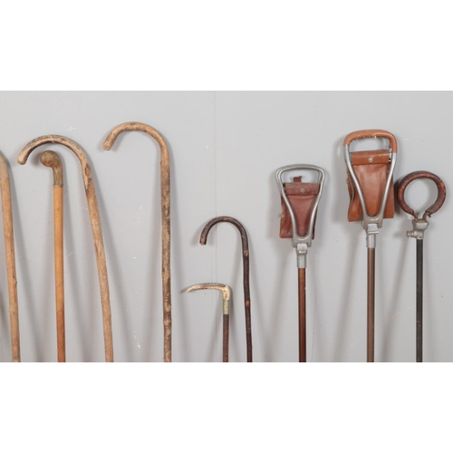 221 - A collection of walking sticks and shooting equipment, to include horn handled examples, along with ... 