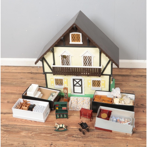 229 - A two storey painted dolls house with four small boxes of furniture and accessories.