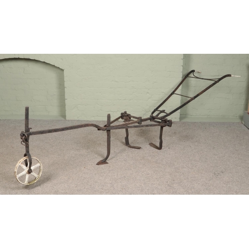 244 - An antique iron two handle plough. Approximate length 310cm.