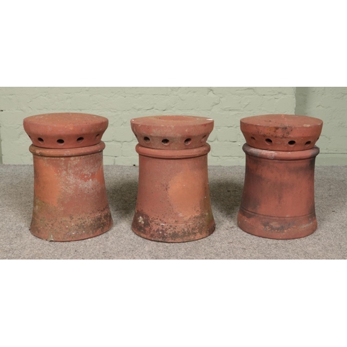 254 - Three small terracotta chimney pots, all having pepper pot style cowls/flues. All approximately 39cm... 