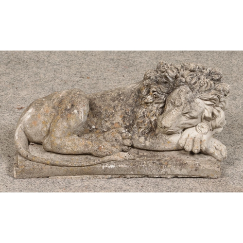 268 - A small concrete garden statue formed as a sleeping lion. 40cm long.