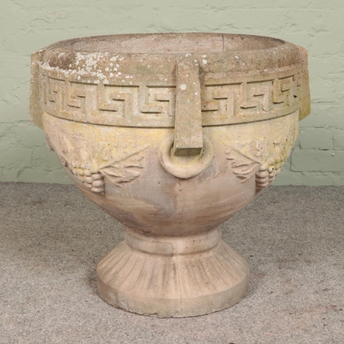 269 - A heavy cast concrete garden urn, with grape and leaf decoration and Greek key border. Diameter of b... 