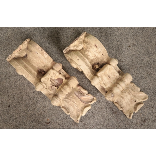 273 - A pair of garden wall corbels, previously painted, with scrolled decoration. Height: 49cm.