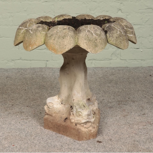 276 - A cast concrete birdbath with dolphin supports. Height: 51cm.