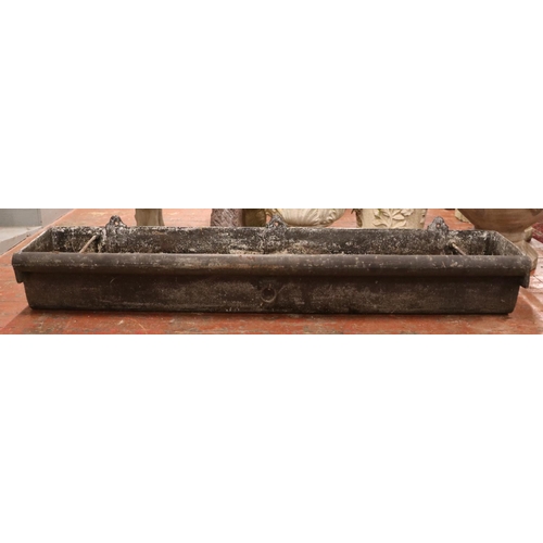 282 - A very large cast iron garden trough, with central tie ring and roll top to one side. Length: 183cm.