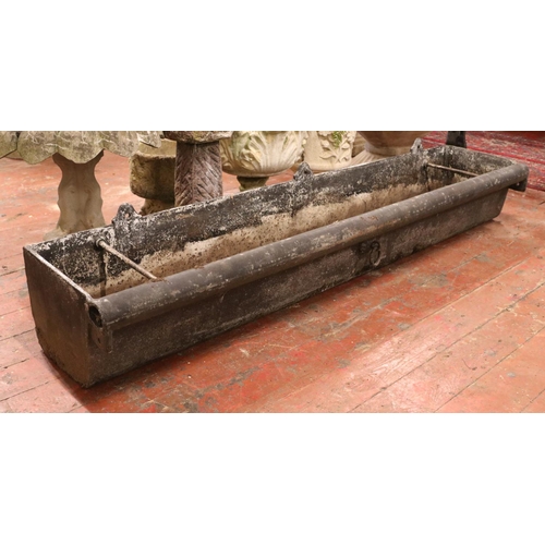 282 - A very large cast iron garden trough, with central tie ring and roll top to one side. Length: 183cm.