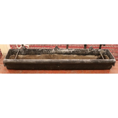 283 - A very large cast iron garden trough, with central tie ring and roll top to one side. Length: 183cm.