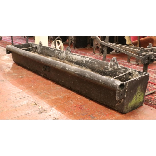 283 - A very large cast iron garden trough, with central tie ring and roll top to one side. Length: 183cm.