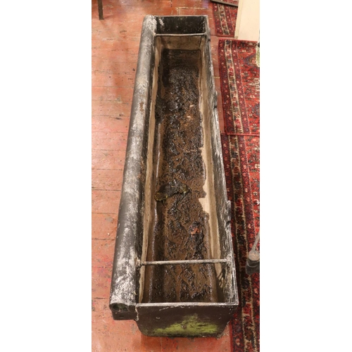 283 - A very large cast iron garden trough, with central tie ring and roll top to one side. Length: 183cm.