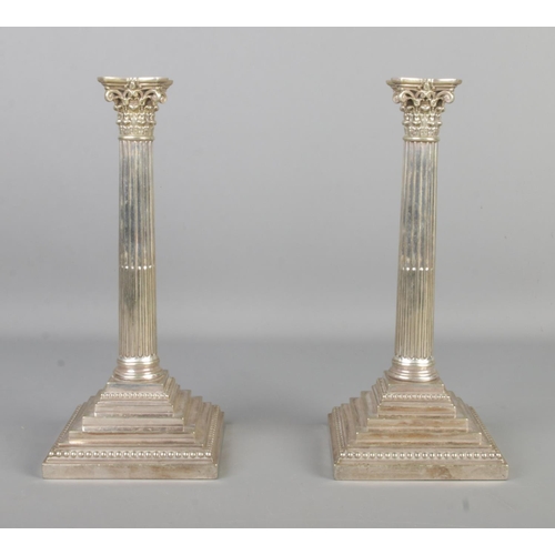 63 - A pair of Richard Hodd and Son silver plated candlesticks, formed as Corinthian columns with sconce ... 