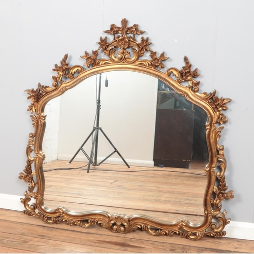 298 - A large, gilt framed ornate mirror, with curved top and floral decoration. Height: 117cm, Width: 120... 